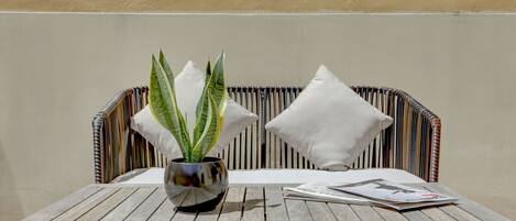 A wooden table with a potted plant and a magazine.