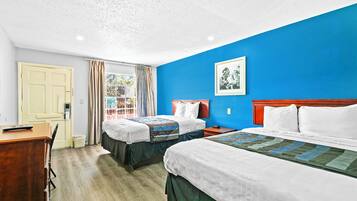 Una habitación de hotel con dos camas, un escritorio y una ventana con cortinas.