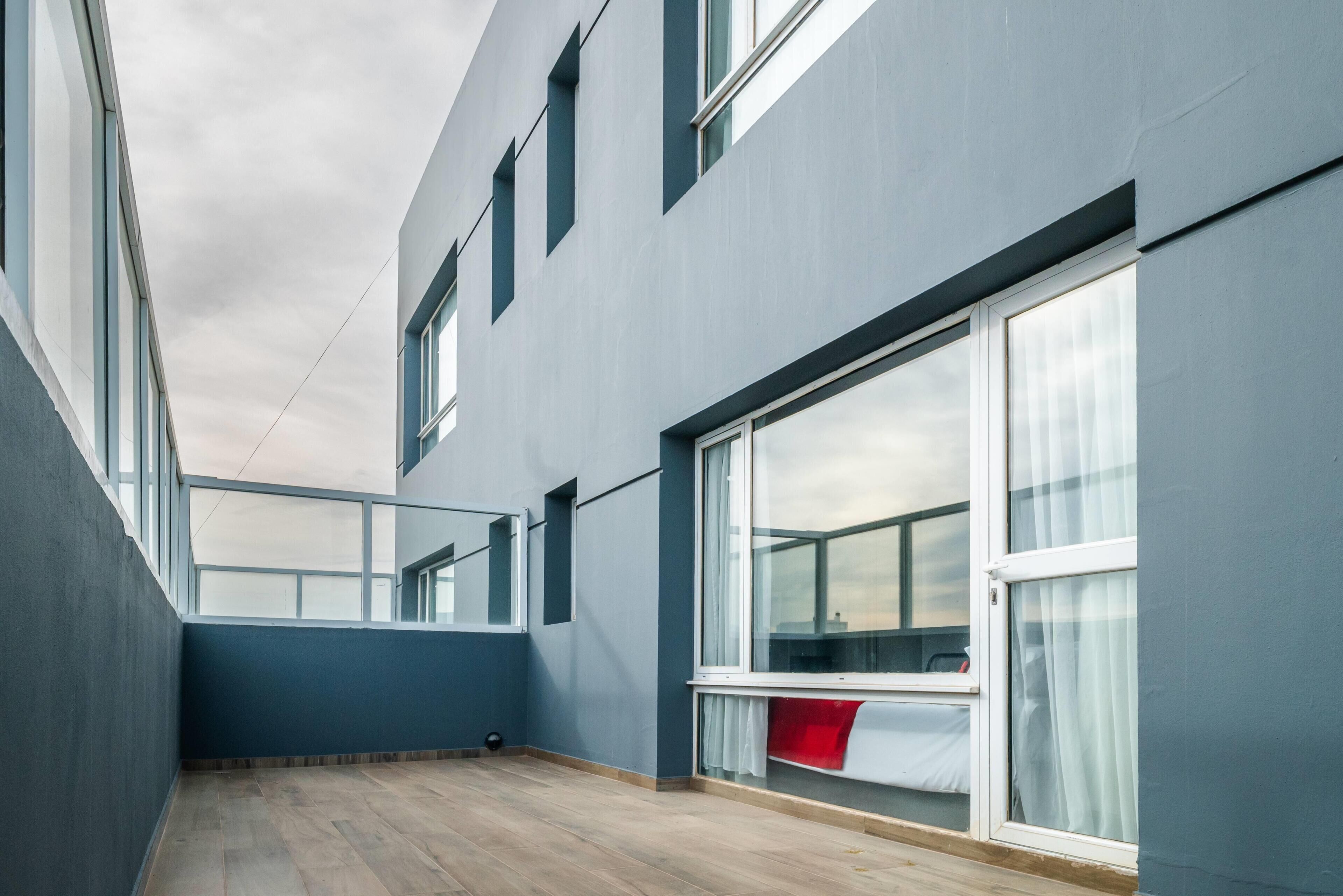 Een modern gebouw met grote ramen, een balkon en een houten vloer.