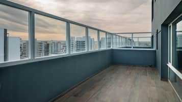 Un edificio alto con balcón, ventanas amplias y piso de madera.