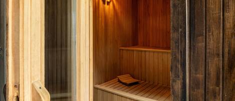A sauna with wooden walls and a bench.