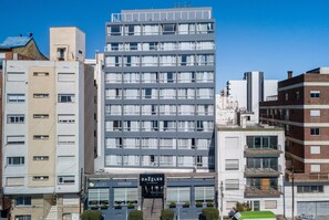 Un edificio de varios pisos con fachada moderna, entrada visible y el letrero de 'DAZZLER'.