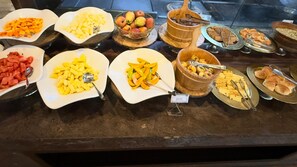 A buffet with various food items including fruits, pastries, and desserts. - The Hridayesh SPA Wilderness Resort (Ramnagar)