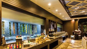 A buffet area with a variety of food items and beverages, a tiled backsplash, and a patterned floor. - The Hridayesh SPA Wilderness Resort (Ramnagar)