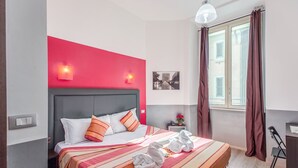 A hotel room with a bed, a nightstand, a lamp, and a window with curtains. - MF Hotel (Rome)