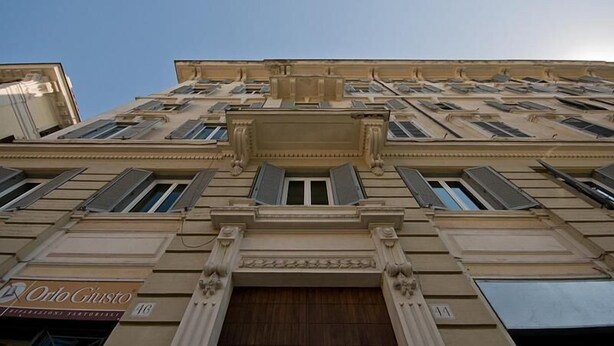 A multi-story building with a classical architectural style, featuring a central entrance with columns and a large wooden door. - MF Hotel (Rome)