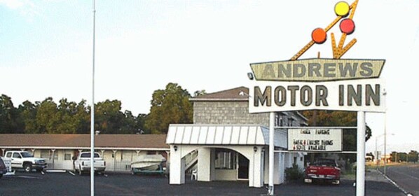 A motel with a sign reading "Andrews Motor Inn" and a parking sign below it.