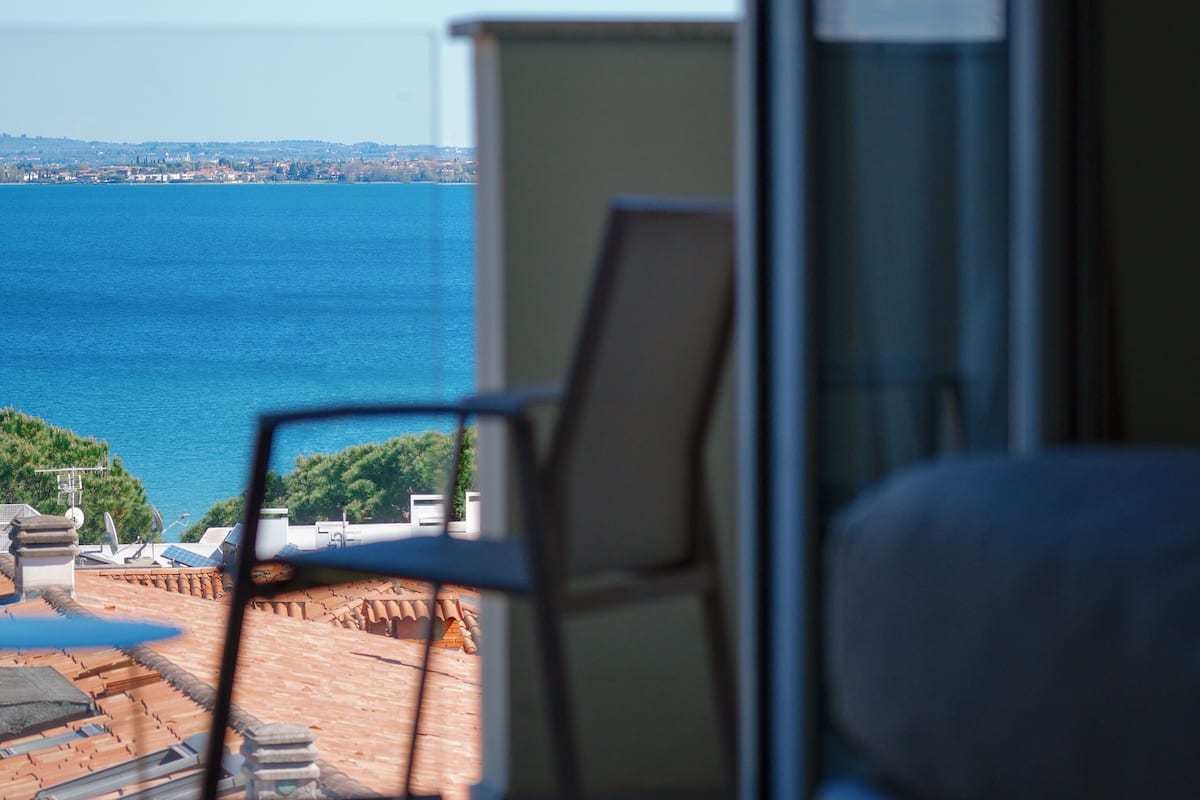 Una habitación con vista al mar, una silla y un sofá.