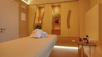 Una habitación de hotel moderna con una cama grande, una mesita redonda y un espejo.