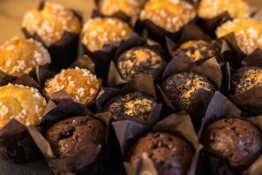 Diverse muffins in papieren bekertjes, waarvan sommige bezaaid met zaden.
