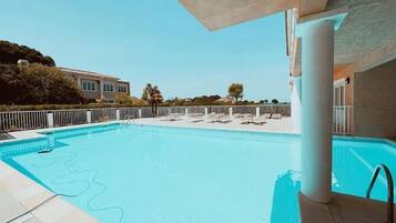 Alberca al aire libre y camastros