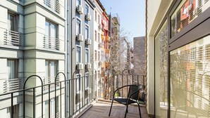 A narrow balcony with a metal railing, a black chair, and a view of adjacent buildings. - Villa Pera Suite Hotel (Istanbul)