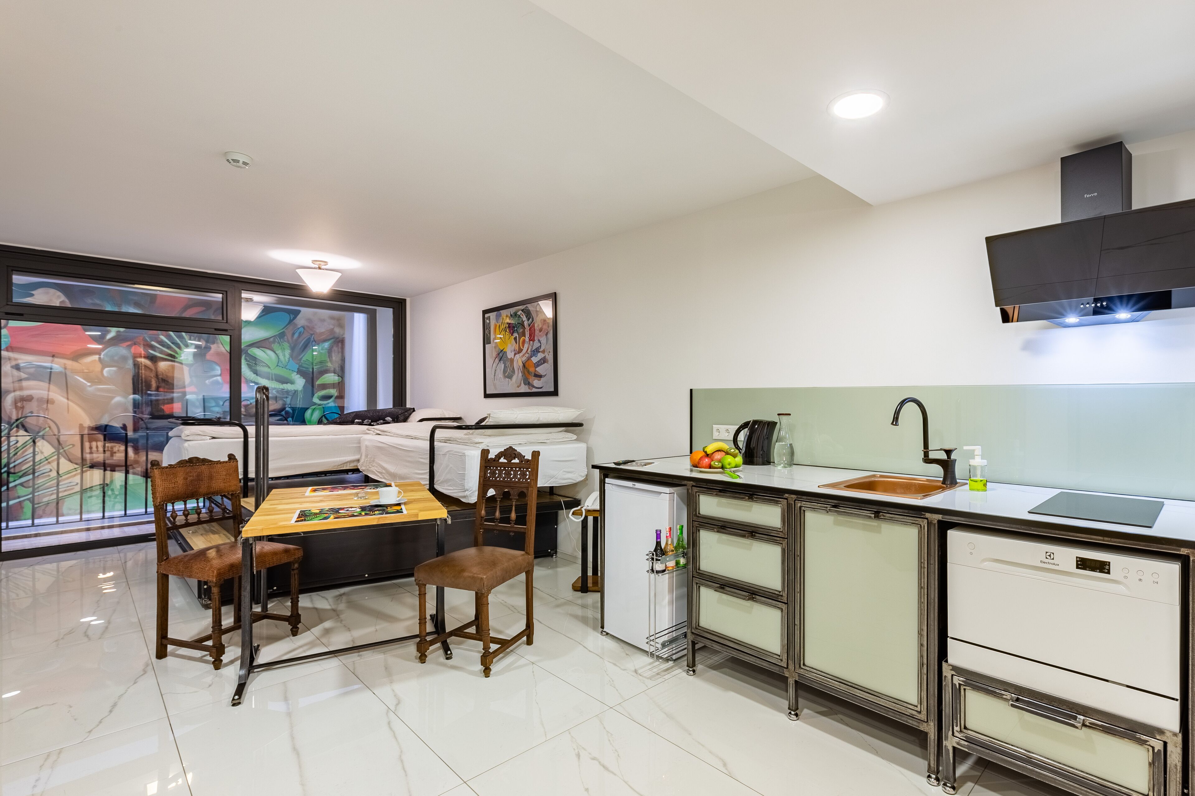 A compact kitchen with a dining area, a refrigerator, and a sink.