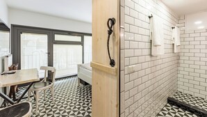 A modern bathroom with white tiles, a wooden partition, and a shower area. - Villa Pera Suite Hotel (Istanbul)