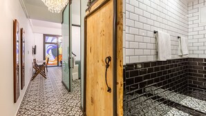 A hallway with patterned floor tiles, a wooden door, and a tiled wall. - Villa Pera Suite Hotel (Istanbul)