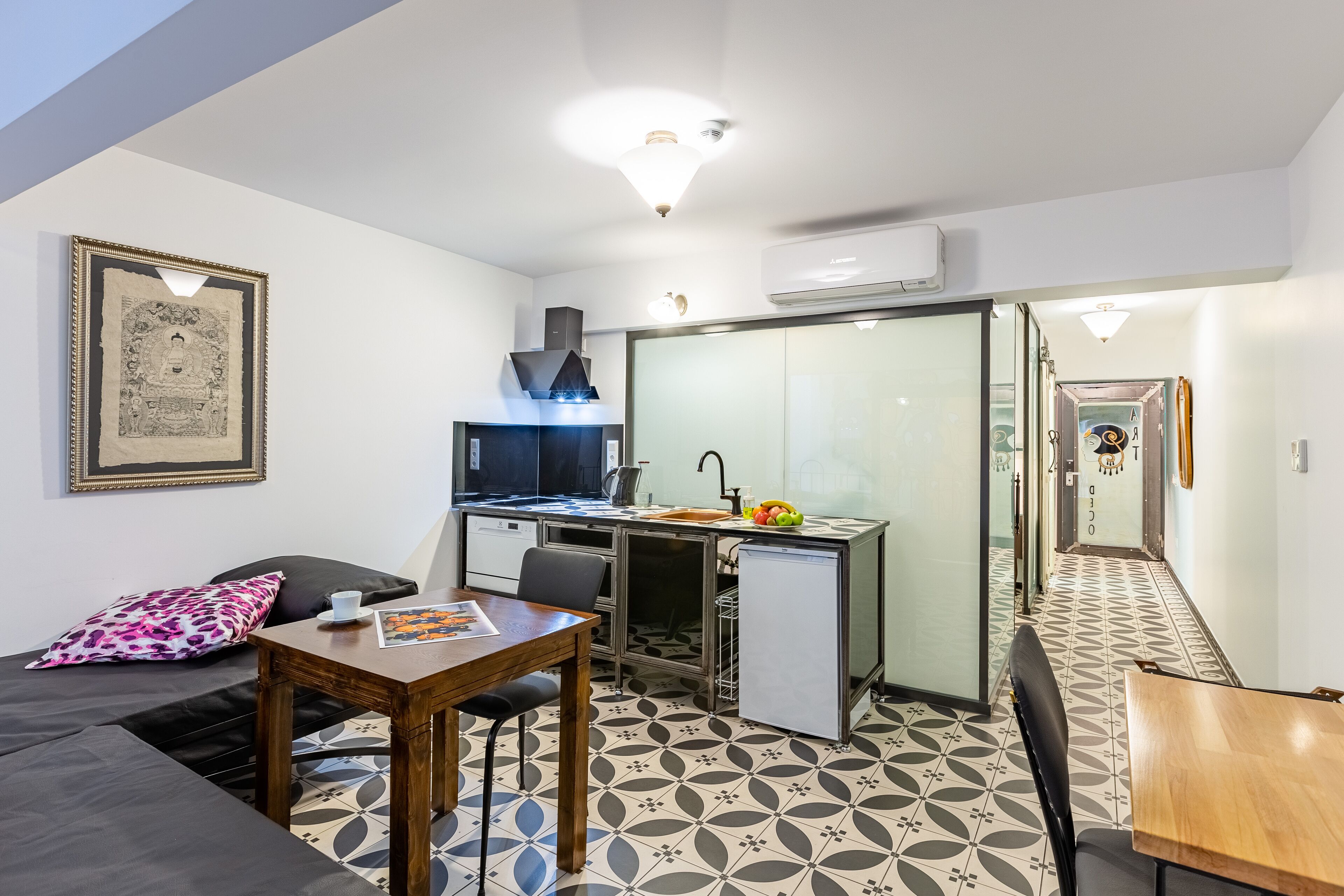 A compact living space with a kitchenette, a dining area, and a small sitting area.