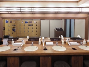 A hotel restroom with multiple sinks, mirrors, and a row of lockers in the background. - Dormy Inn Sendai ANNEX Natural Hot Spring (Sendai)