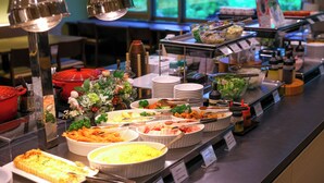 A buffet with various dishes and condiments.