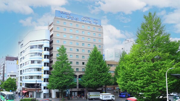 A multi-story hotel with a prominent sign for 'Hotel Darby Inn' and 'Hotel Darby Inn' in English.
