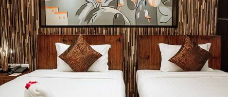 Habitación de hotel con dos camas, cada una con cabecero de madera y un gran mural en la pared.