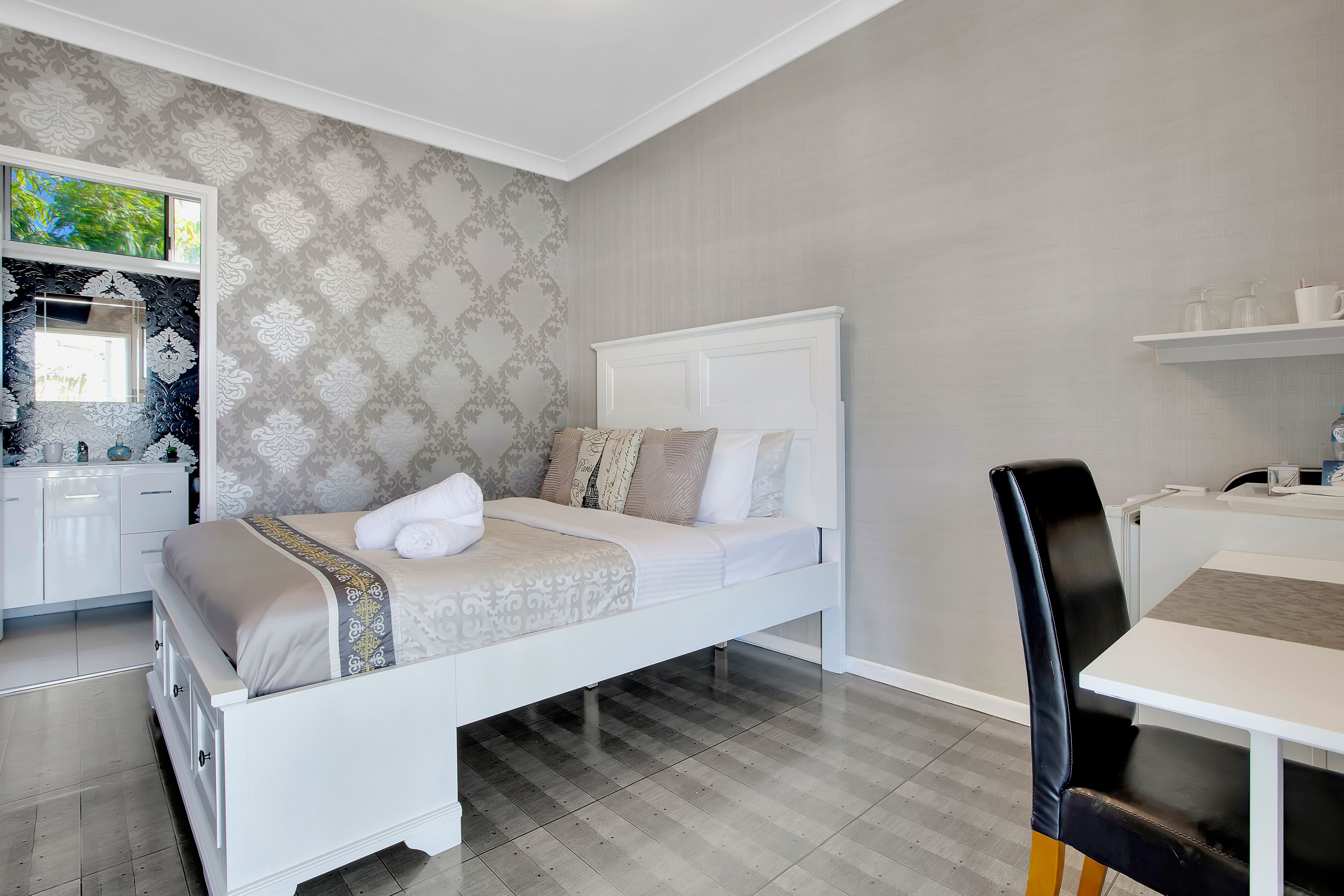 A bedroom with a bed, a desk, and a chair.