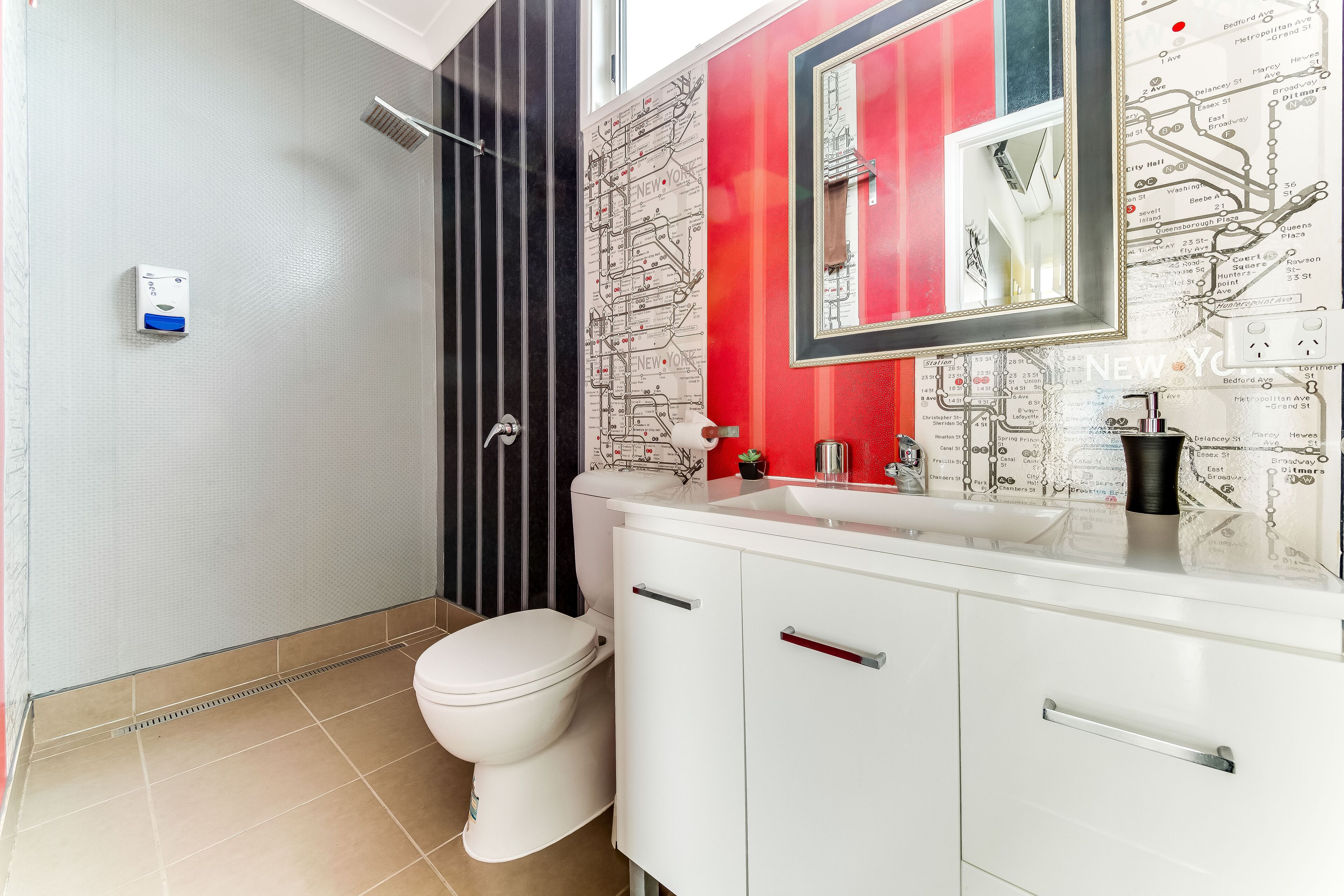 Un bany amb vàter, dutxa i un lavabo amb mirall.