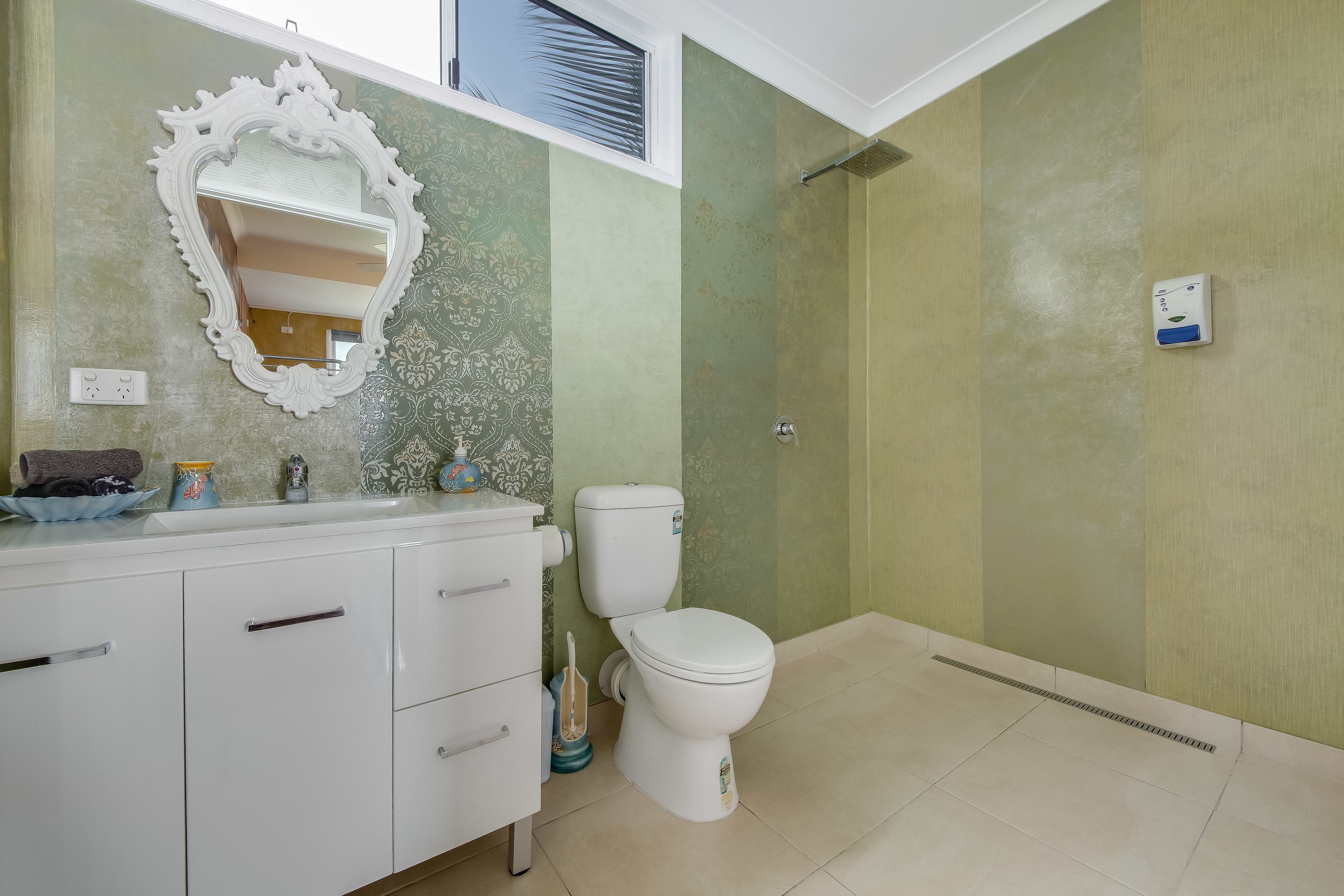Un baño con tocador blanco, inodoro y ducha.