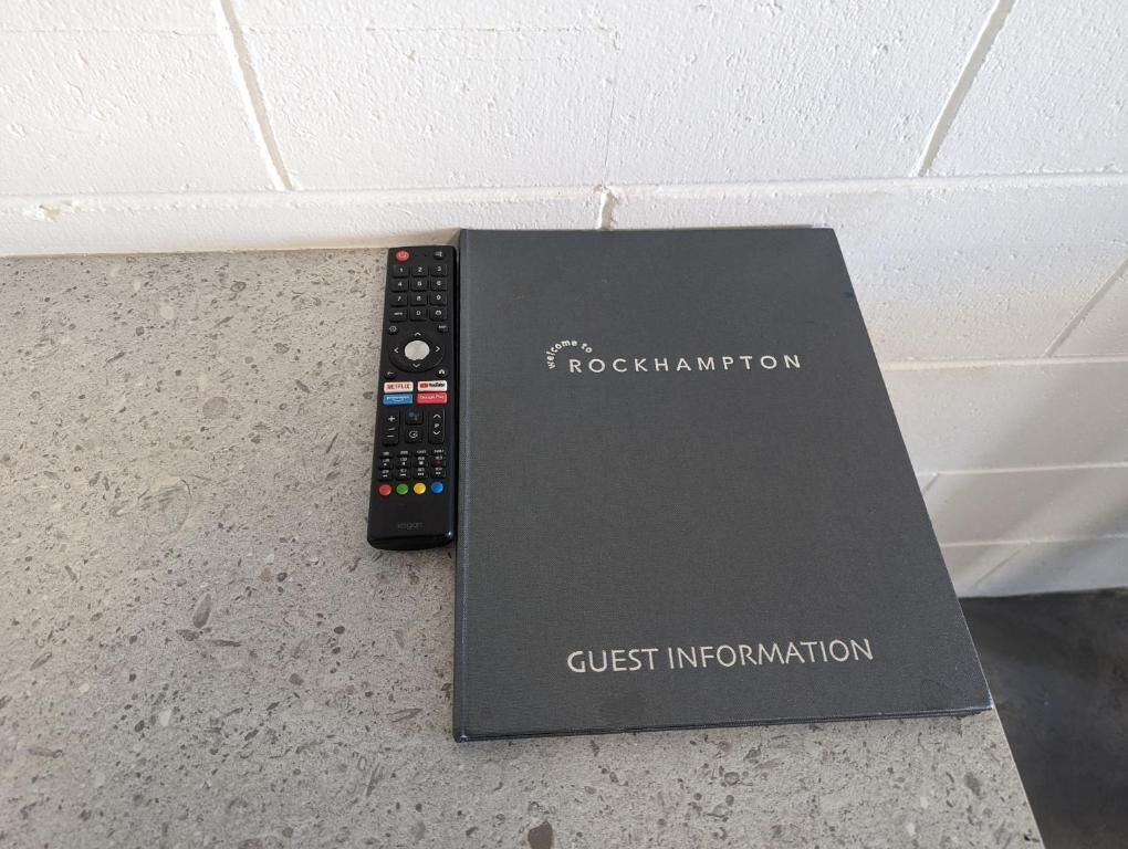Une boîte noire portant l’inscription « Informations pour les clients de Rockhampton » sur une surface texturée.