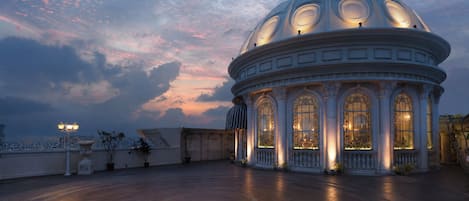 Un edificio imponente con una gran cúpula y ventanas de arco, rodeado por un amplio patio.