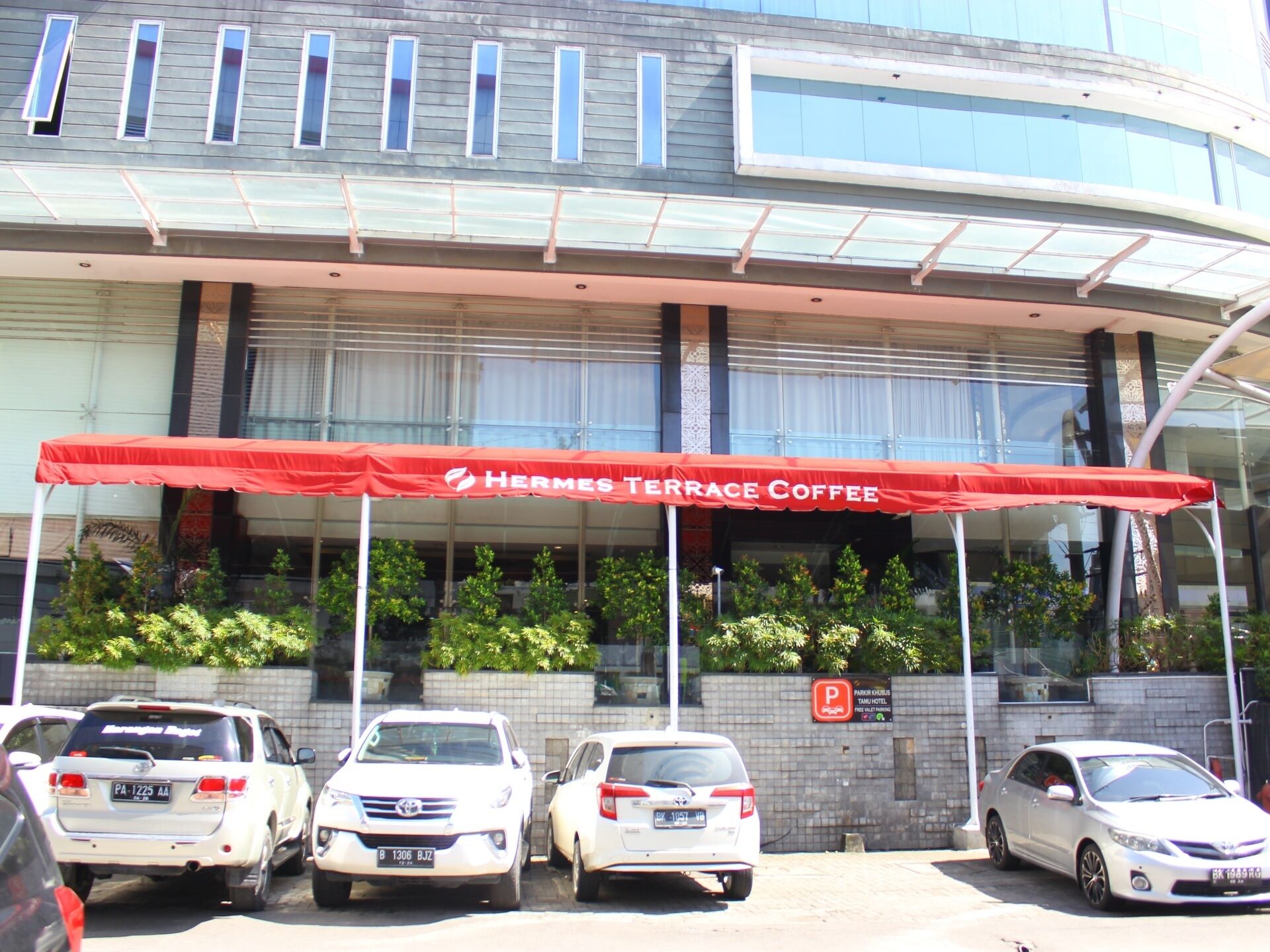 Un edificio moderno con un toldo rojo que dice 