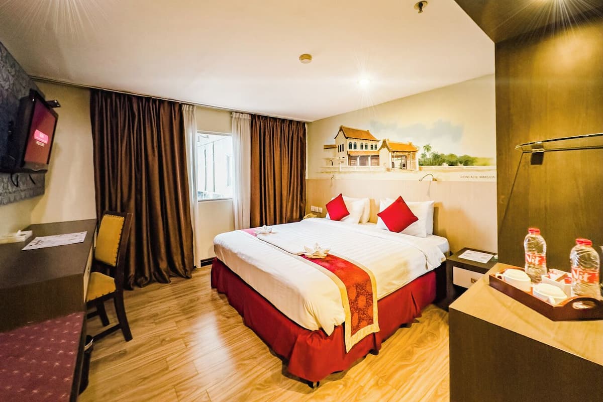 Ein Hotelzimmer mit einem großen Bett, einem Schreibtisch und einem Stuhl.