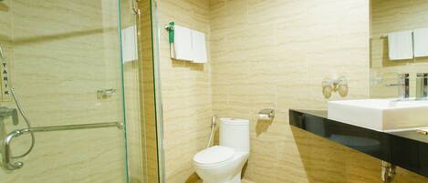 A modern bathroom with a glass shower enclosure, a white toilet, and a black countertop with a sink.