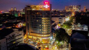 A high-rise hotel with multiple floors, a prominent sign at the top, and a busy street in the foreground.