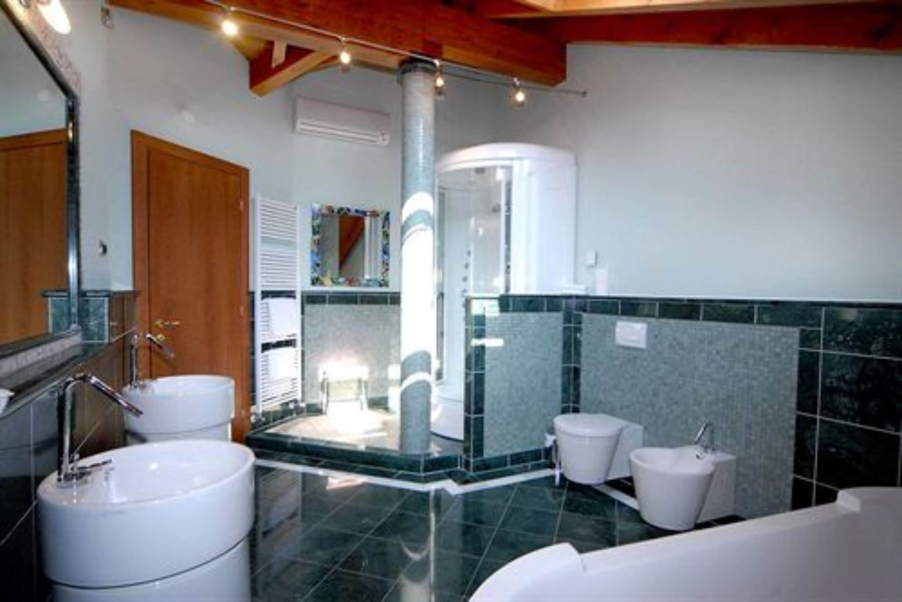 Un baño moderno con ducha central, dos lavamanos y una bañera.