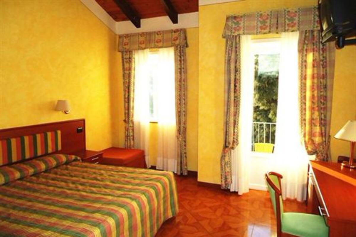 Een kamer met een bed, een bureau en een stoel.