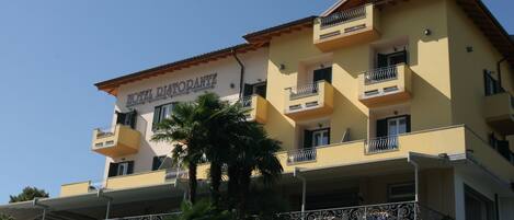 Un hotel de varios pisos con balcones y un cartel que dice 'HOTEL RISTORANTE'.