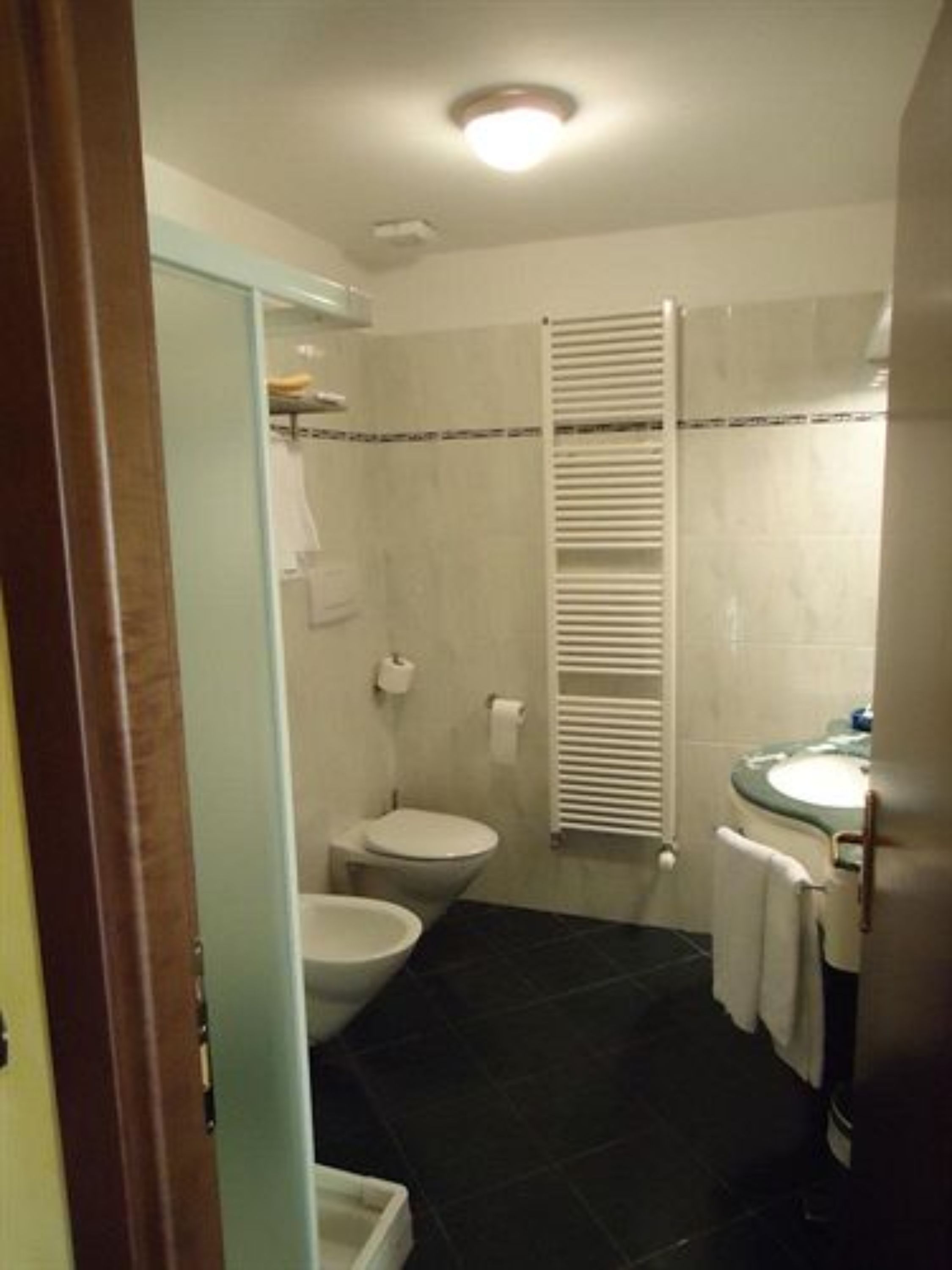 A bathroom with a toilet, bidet, and sink.
