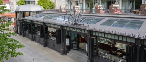 A hotel with a glass roof, outdoor seating, and a sign reading "EUROPA HOTEL".