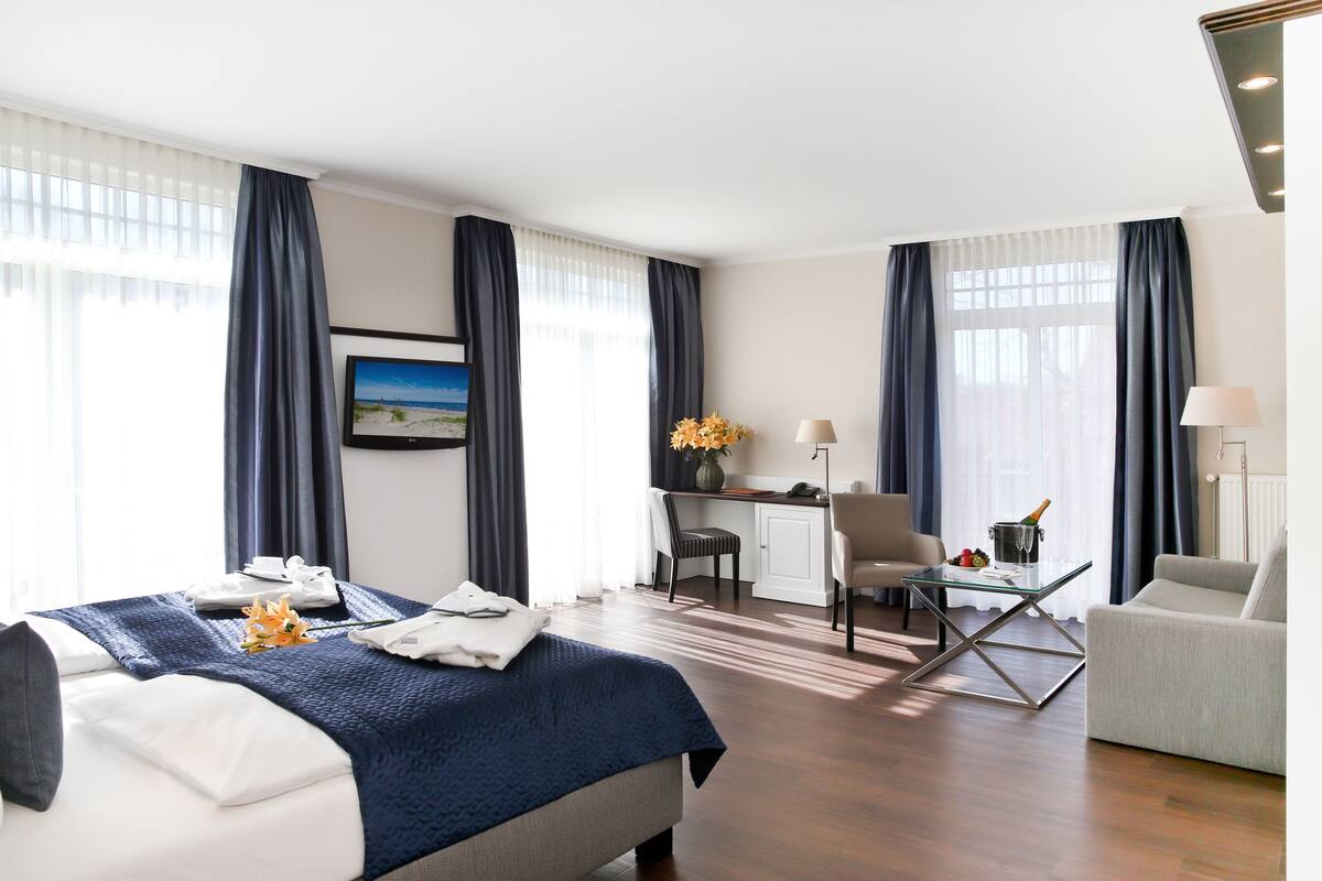 Habitación de hotel con cama, escritorio y zona de estar.