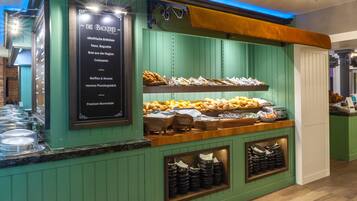 A buffet counter with a variety of food items and a menu board.