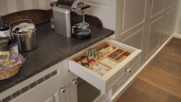 Een keuken met een koffiezetapparaat, waterkoker en een lade-organizer.