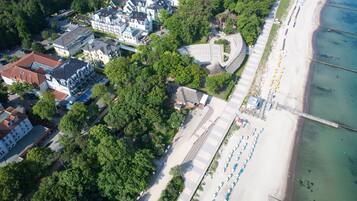 Enjoy a serene beachside promenade with a wooden walkway and comfortable seating areas.
