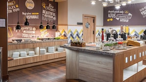 A modern buffet setup with a variety of food items and a motivational wall. - Hampton by Hilton Warsaw Airport (Warsaw)
