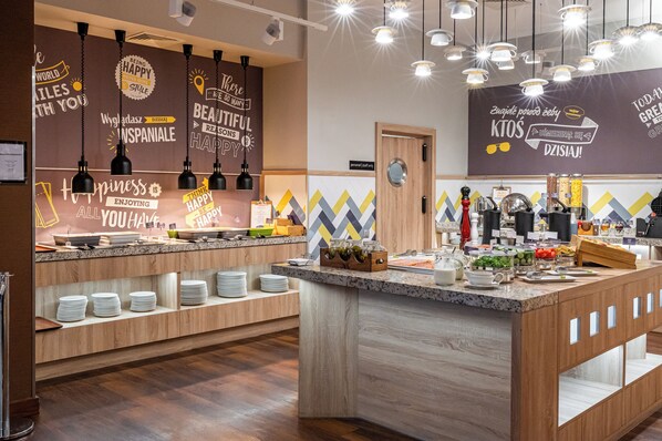 A modern buffet setup with a variety of food items and a motivational wall. - Hampton by Hilton Warsaw Airport (Warsaw)