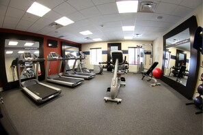 A gym with treadmills, elliptical machines, and weight equipment.