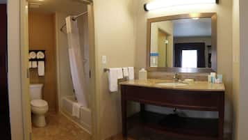 A bathroom with a toilet, shower, and sink.