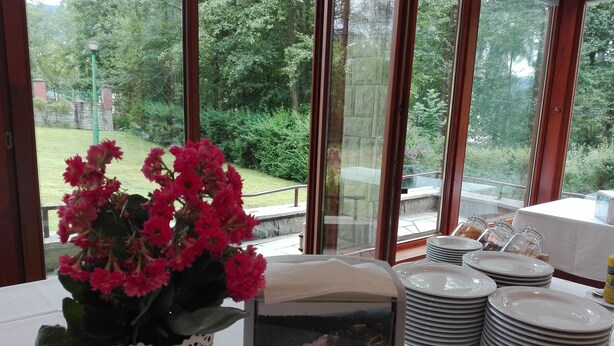 Een tafel met een potplant, een ingelijste foto en gestapelde borden.