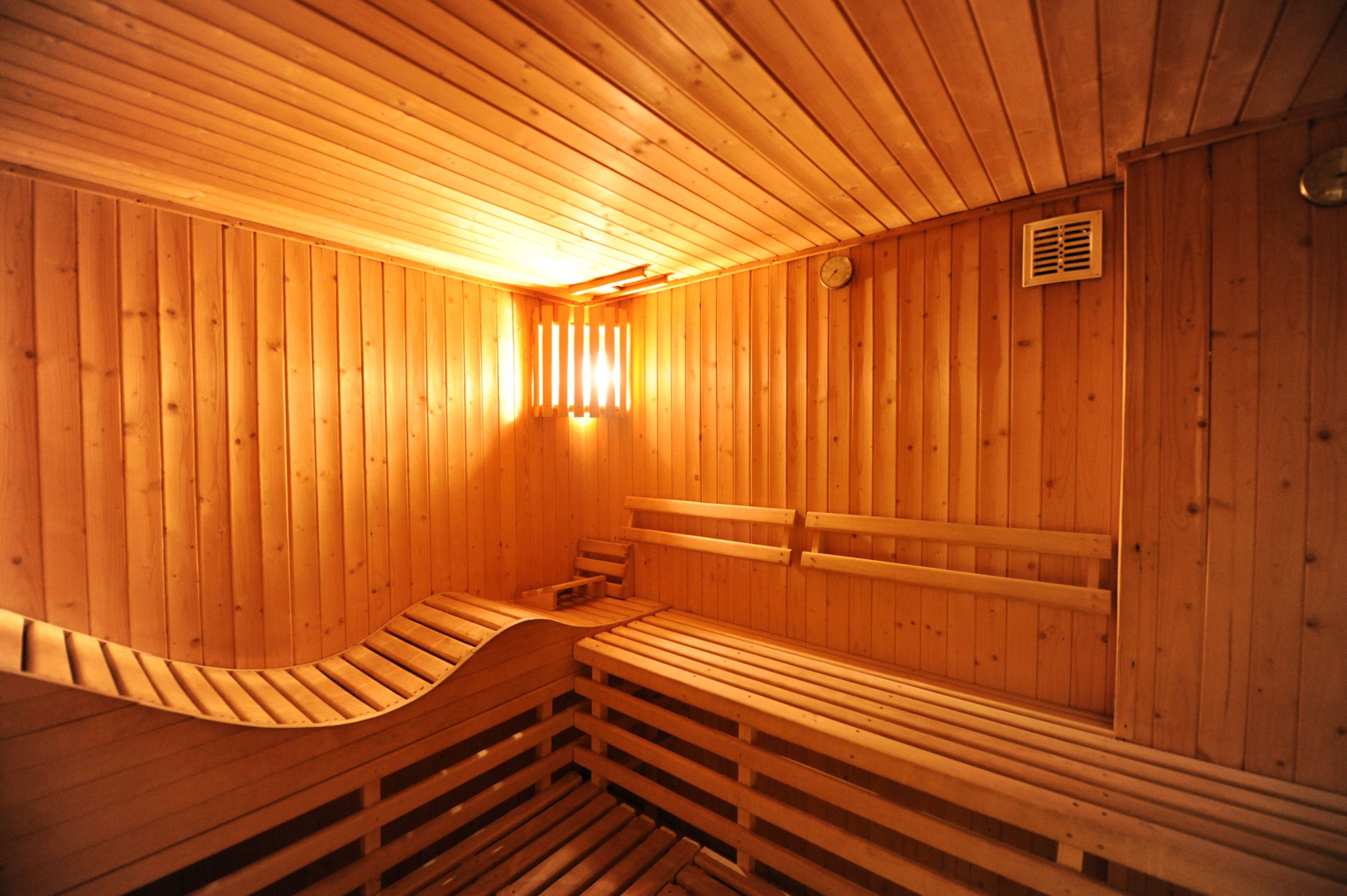 Una sauna de madera con bancos y techo inclinado.
