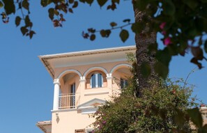A building with a balcony and arched windows. - Hôtel Reine D'Azur (Roquebrune-Cap-Martin)