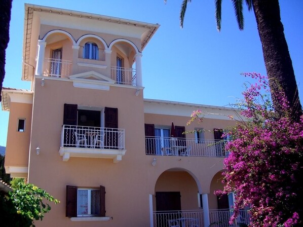 A multi-story building with balconies, arched windows, and a flat roof. - Hôtel Reine D'Azur (Roquebrune-Cap-Martin)